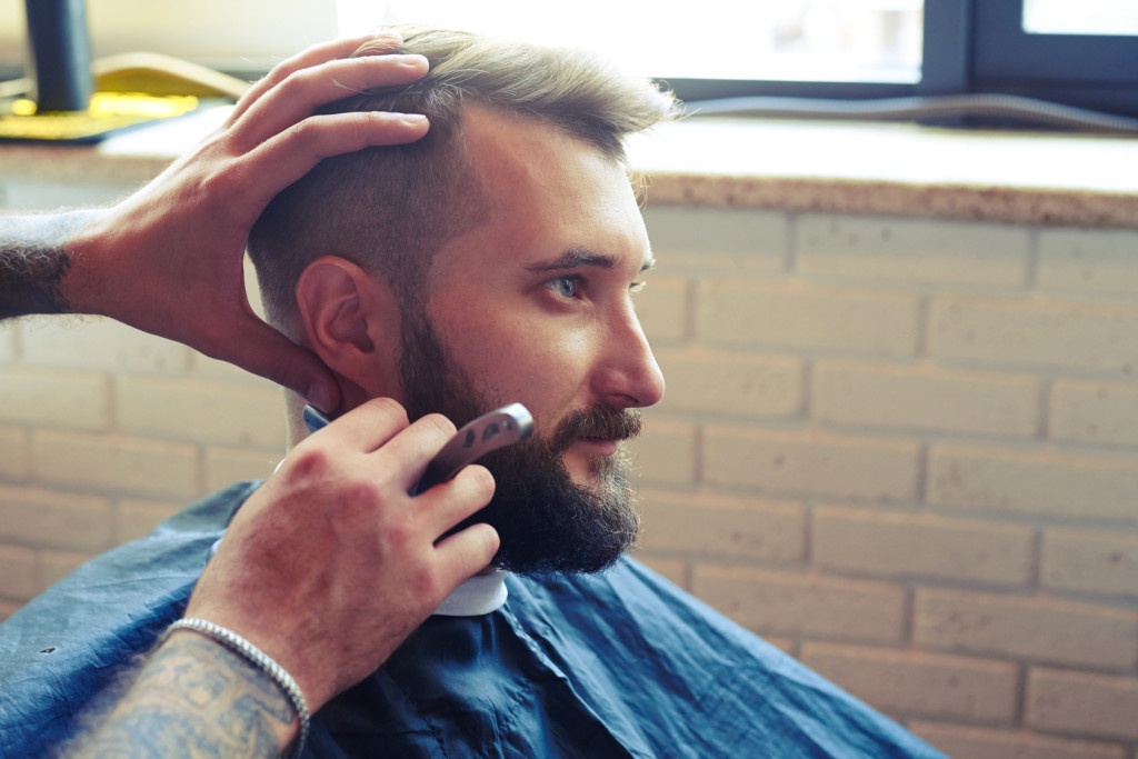 man shaving with straight razor